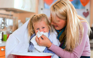 Женщина вытирает нос ребенку